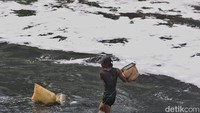 Tampak air sungai menghitam dan berbuih namun tak dihiraukan pencari cacing sutra.