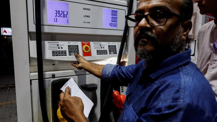 Pakistan Berlakukan Subsidi BBM untuk Kendaraan Kecil A worker checks customers' mobile phones for a code before refuelling their vehicles at a petrol station following the rollout of a fuel relief scheme, which provides a fuel subsidy for eligible motorcycles, rickshaws and vehicles with engines of up to 800cc, in Karachi, Pakistan, September 17, 2026. REUTERS/Akhtar Soomro