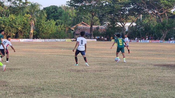 Pemain tim Indramayu (hijau) menggiring bola dalam sebuah pertandingan menghadapi Mundu Permai FC.