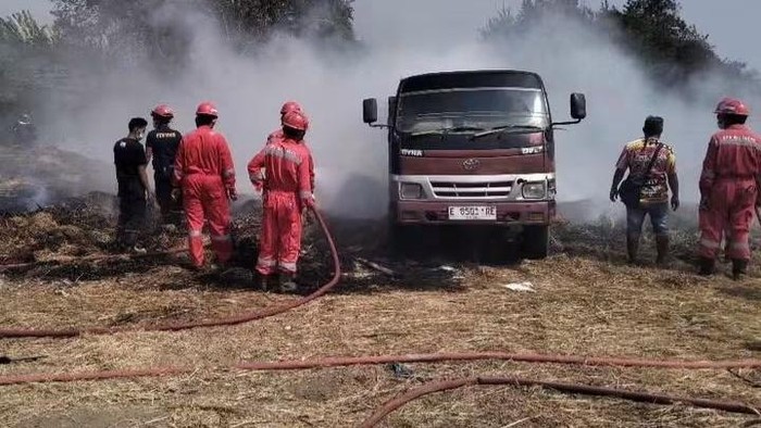 Petugas damkar memadamkan api yang menghanguskan mobil dump truk di Balongan.