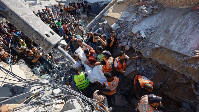 SENSITIVE MATERIAL. THIS IMAGE MAY OFFEND OR DISTURB    Rescuers recover the body of a Palestinian from under the rubble of a residential building that had been damaged in an earlier Israeli strike during the war and collapsed on Wednesday, in Gaza C