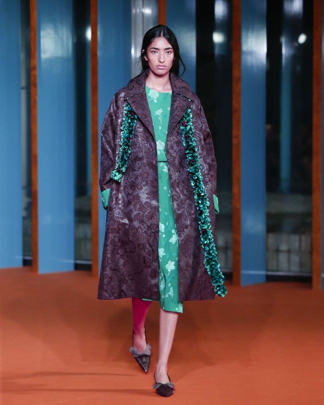 Untuk sepatu, inspirasi datang dari cara kain membungkus tubuh. Peep-toe pumps dan Venetian-style slippers dibuat dengan konstruksi yang membungkus dan melipat secara elegan di sekitar kaki. Leather cord ditenun menjadi slingback, sementara thong dihiasi detail mother-of-pearl, beads, dan faux shark teeth. Beberapa gaya juga menampilkan sol dengan sentuhan lukis tangan serta detail spiral pada bagian hak. (Foto: Dan Lecca)