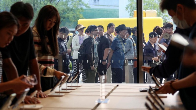 Customers look at the new iPhone 18 Pro series smartphones on display as the models go on sale, at an Apple store in Beijing, China September 18, 2026. REUTERS/Tingshu Wang