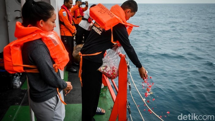 Anak dari jurnalis iNews, Yudistiro Pranoto, Kenzie Hafizan Pranoto (kanan), bersama ibunya, Rodiah Nasution (kiri), melakukan tabur bunga dari atas kapal KN SAR 247 Tetuka di Perairan Selat Sunda, Banten, Jumat (18/9/2026). Tabur bunga tersebut dila