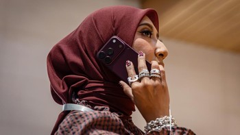 Seorang kreator konten asal Malaysia berpose dengan iPhone 18 Pro warna Burgundy di Apple Store Exchange TRX, Kuala Lumpur, Malaysia, Jumat (18/9/2026). Aktivitas tersebut dilakukan saat peluncuran dan penjualan perdana iPhone terbaru Apple di Malaysia. Getty Images/Annice Lyn 