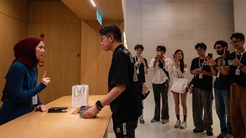 Pelanggan pertama yang mengantre dilayani staf Apple Genius saat mengambil iPhone yang baru dibeli di Apple Store Exchange TRX, Kuala Lumpur, Malaysia, Jumat (18/9/2026). Momen tersebut menandai dimulainya penjualan perdana iPhone terbaru Apple di Malaysia. Getty Images/Annice Lyn 