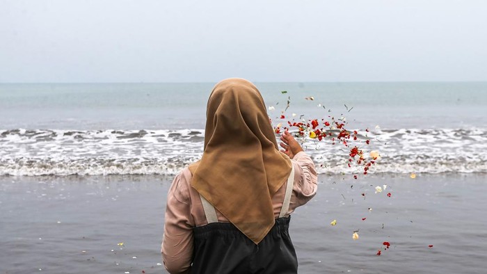 Tabur bunga untuk jurnalis dan awak kapal yang hilang kontak Seorang jurnalis melakukan tabur bunga di bibir Pantai Kampung Pagedongan, Carita, Pandeglang, Banten, Jumat (18/9/2026). Keluarga, kerabat, beserta rekan-rekan jurnalis menggelar prosesi tabur bunga di sekitar titik awal keberangkatan lima jurnalis, dua awak kapal dan seorang pemandu untuk meliput erupsi Gunung Anak Krakatau setelah operasi pencarian oleh Tim SAR gabungan resmi dihentikan usai 10 hari pelaksanaan. ANTARA FOTO/Angga Budhiyanto/agr