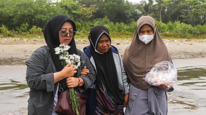 Tabur bunga untuk jurnalis dan awak kapal yang hilang kontak Istri dan ibu jurnalis ANTARA yang hilang kontak, M Bagus Khoirunas, Desi Purnama Sari (kiri) dan Tini (tengah) berdoa usai melakukan tabur bunga di bibir Pantai Kampung Pagedongan, Carita, Pandeglang, Banten, Jumat (18/9/2026). Keluarga, kerabat, beserta rekan-rekan jurnalis menggelar prosesi tabur bunga di sekitar titik awal keberangkatan lima jurnalis, dua awak kapal dan seorang pemandu untuk meliput erupsi Gunung Anak Krakatau setelah operasi pencarian oleh Tim SAR gabungan resmi dihentikan usai 10 hari pelaksanaan. ANTARA FOTO/Angga Budhiyanto/agr