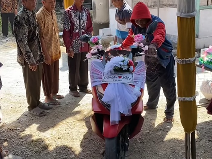 Viral momen nikah sederhana berbusana adat Jawa. Meski bertema simpel, pengantin pria memboyong mahar motor Honda PCX merah serta perabotan rumah tangga.