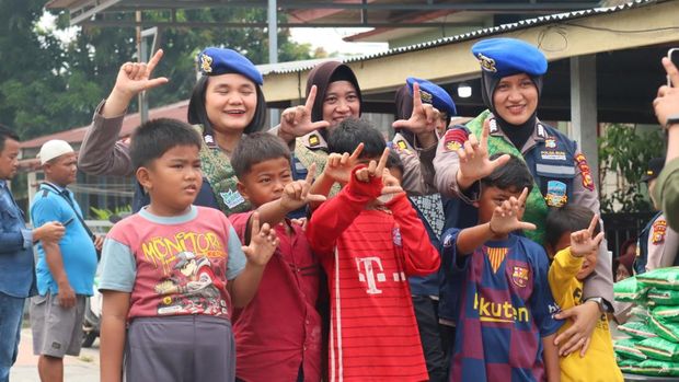 Polwan Polda Riau turun membagikan sembako kepada warga di pesisir Sungai Duku, Pekanbaru melalui program 'JALUR', Jumat (18/9/2026).