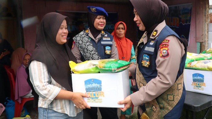 Polwan Polda Riau turun membagikan sembako kepada warga di pesisir Sungai Duku, Pekanbaru melalui program JALUR, Jumat (18/9/2026).