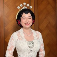 Amanda diketahui mengenakan kebaya rancangan Didiet Maulana. Kebaya putih dengan potongan yang mengikuti bentuk tubuh itu dihiasi bordir motif bunga, payet, serta embellishment berkilau yang memberikan kesan mewah. Detail floral tiga dimensi juga terlihat menyebar dari bagian bahu hingga lengan. Foto: Instagram/@leoafandi_