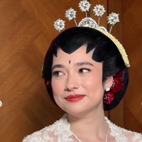 Di bagian tengah dada terdapat bros besar bernuansa silver yang dihiasi susunan kristal. Bentuknya menyerupai rangkaian bunga atau ornamen permata yang menjuntai ke bawah.  Foto: Instagram/@leoafandi_
