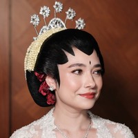 Sementara untuk riasan wajah, Amanda mempercayakan pada MUA Leo Afandi. Riasannya dibuat dengan konsep soft glam yang tetap terlihat natural. Complexion tampak halus, bersih, dan sedikit glowing. Mata dipertegas dengan eyeshadow cokelat lembut, eyeliner tipis, serta bulu mata yang lentik. Blush bernuansa pink-peach memberikan rona segar pada pipi, sementara bibir menggunakan warna merah bata atau merah kecokelatan dengan sedikit efek glossy. Foto: Instagram/@leoafandi_