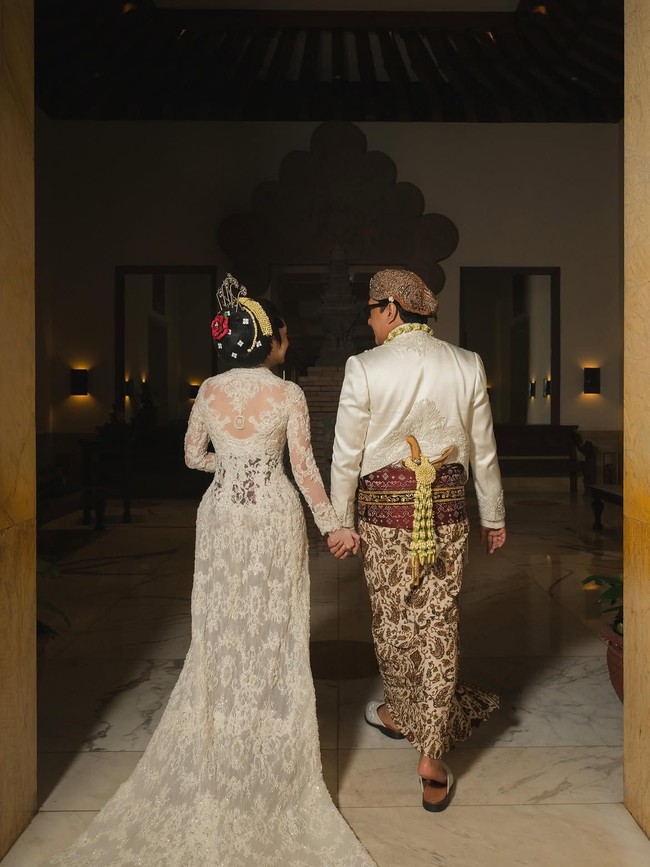 Kebaya Amanda Rigby hadir dengan ekor panjang yang dramatis. Seluruh permukaan belakang kebaya dilapisi brokat dan payet putih bernuansa klasik. Foto: Instagram @andreastaulany (Foto dan video @derai.studio)