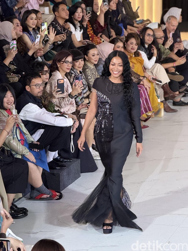 Anggun muncul dalam balutan gaun hitam bersiluet mermaid dengan potongan asimetris pada lengan dan bodice yang dihiasi detail beading. Sang desainer, Mel Ahyar, terinspirasi dari keindahan budaya Nias, Sumatera Utara, untuk koleksi bertajuk Tano Niha. (Foto: Daniel Ngantung/detikcom)