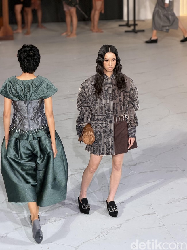 Sebelum Anggun, Kirana yang juga menjadi muse Mel, memeragakan oversized blouse abu-abu berhiaskan detail bordiran bernuansa etnik. Dengan padanan rok pendek, tas kulit berbentuk tabung, serta sepasang wedges hitam bergaya velvet, look terasa lebih urban dan muda sesuai dengan karakter Kirana.  (Foto: Daniel Ngantung/detikcom)