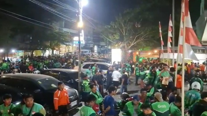 Massa ojol menggeruduk Mapolsek Mamajang usai rekannya ditikam jukir liar di Makassar.