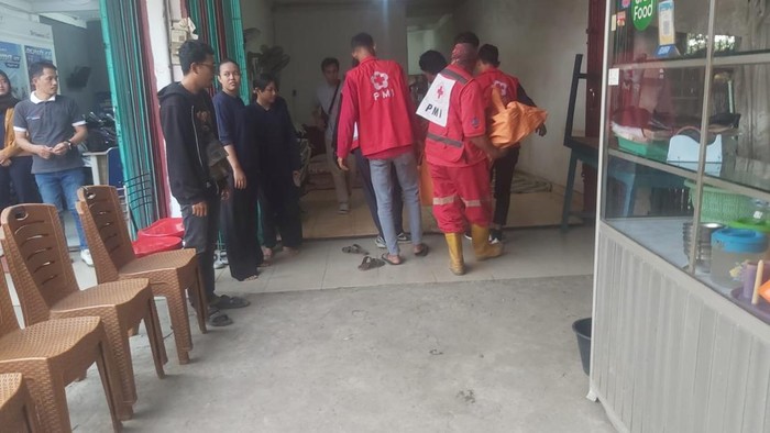 Polisi dan PMI saat mengevakuasi jasad korban