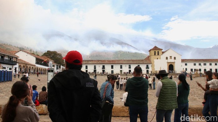 A man uses a hose during efforts to contain a wildfire in Villa de Leyva, Colombia, September 20, 2026. REUTERS/Sebastian Arguello