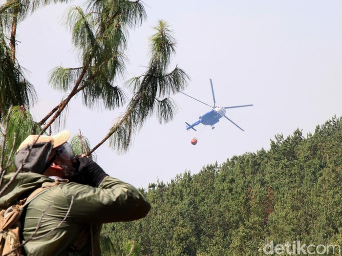 A man uses a hose during efforts to contain a wildfire in Villa de Leyva, Colombia, September 20, 2026. REUTERS/Sebastian Arguello