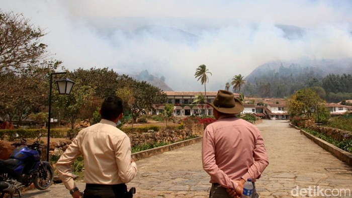 A man uses a hose during efforts to contain a wildfire in Villa de Leyva, Colombia, September 20, 2026. REUTERS/Sebastian Arguello