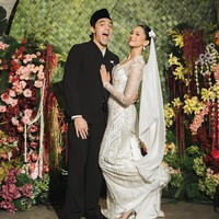 Givina kemudian melengkapi penampilannya dengan veil putih panjang. Rambutnya ditata sleek ke belakang, dengan aksesori bunga putih di sisi kepala yang menjadi detail manis pada keseluruhan look. Kontras busana keduanya justru membuat penampilan mereka terlihat semakin serasi. Mario dengan busana hitam yang minimalis, sementara Givina hadir dalam gaun putih penuh detail dan kilauan kristal. Foto: Instagram @caesarmario