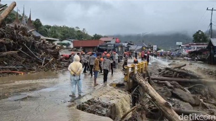 Proses perbaikan badan jalan yang dipenuhi banjir bandang di Solok, Sumbar.