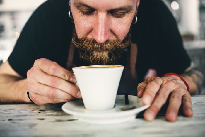 Pria menghirup aroma kopi.