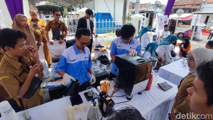 Reza sedang meracik minuman kopi di sebuah stan kegiatan festival di halaman Gedung Perpustakaan Ciamis.