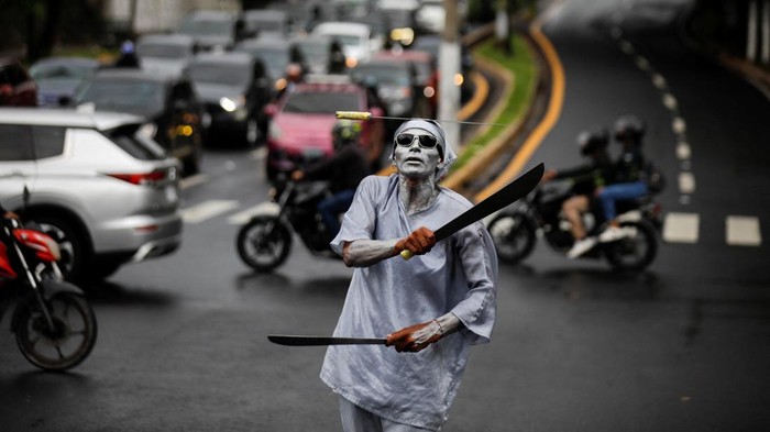 Street performer Samuel Gutierrez performs with machetes at an intersection in San Salvador, El Salvador, September 22, 2026. REUTERS/Jose Cabezas