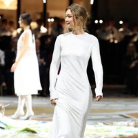 Tak hanya satu look, Gigi kembali tampil di runway dengan penampilan keduanya, mengenakan gaun putih. Foto: Getty Images for Vogue/Daniele Venturelli