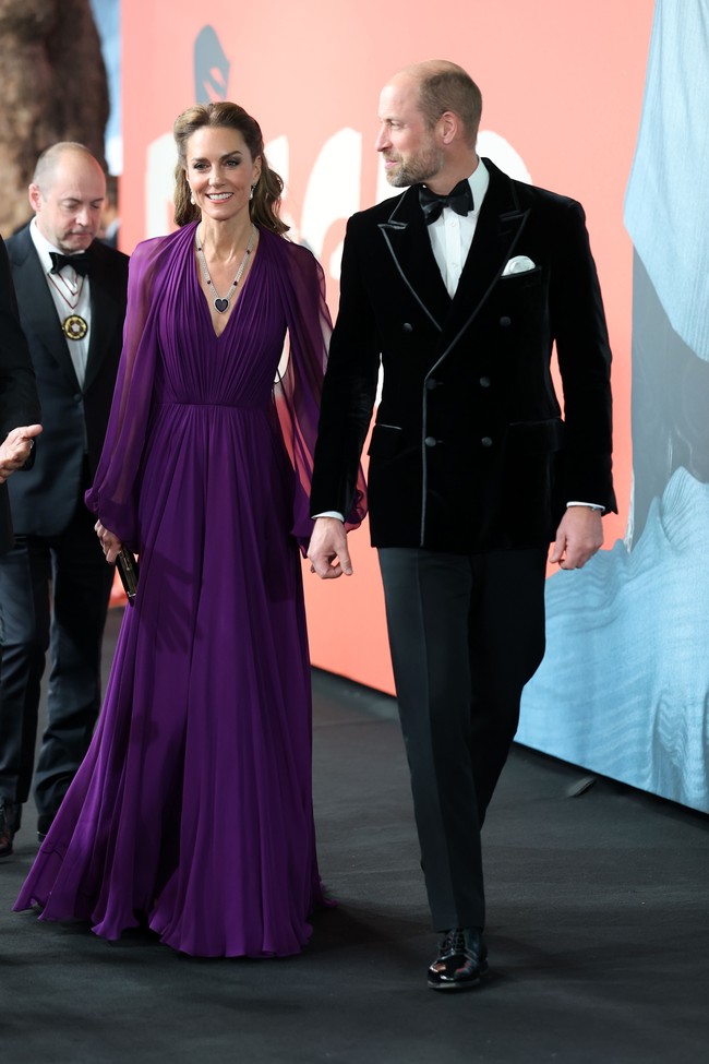 Princess of Wales tampak elegan dalam balutan gaun dari Jenny Packham, lengkap dengan perhiasan kerajaan yang memiliki nilai sentimental. Kate hadir ditemani Pangeran William yang tampil formal dalam setelan tuxedo beludru hitam dengan detail trim berwarna silver dan dasi kupu-kupu senada. Foto: Getty Images for Warner Bros./Chris Jackson