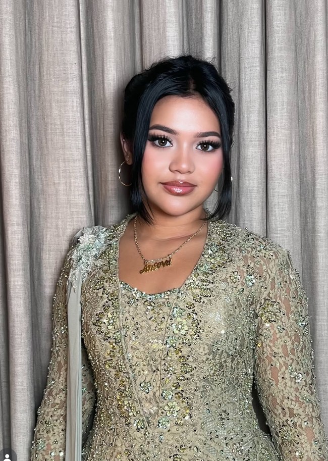 Membuat penampilannya telihat semakin formal, terdapat detail seperti kain panjang yang terpasang di salah satu bahunya. Rambutnya juga tampak rapi dengan disanggul ke belakang dan menyisakan poni panjang di bagian kiri dan kanan wajahnya. Foto: Instagram/@dorotheasbeaautybar