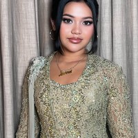 Membuat penampilannya telihat semakin formal, terdapat detail seperti kain panjang yang terpasang di salah satu bahunya. Rambutnya juga tampak rapi dengan disanggul ke belakang dan menyisakan poni panjang di bagian kiri dan kanan wajahnya. Foto: Instagram/@dorotheasbeaautybar