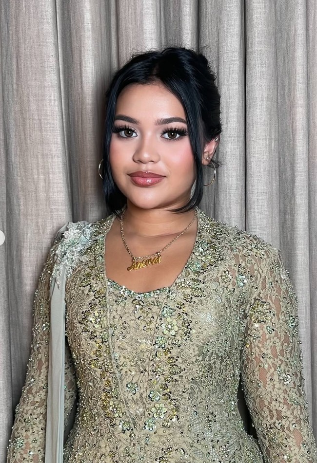 Penampilannya semakin lengkap dengan beberapa aksesori seperti kalung dan anting. Lova tampak mengenakan kalung dengan tulisan namanya. Sementara untuk anting ia memilih sepasang anting hoop yang juga berwarna silver, senada dengan kalungnya. Foto: Instagram/@dorotheasbeaautybar