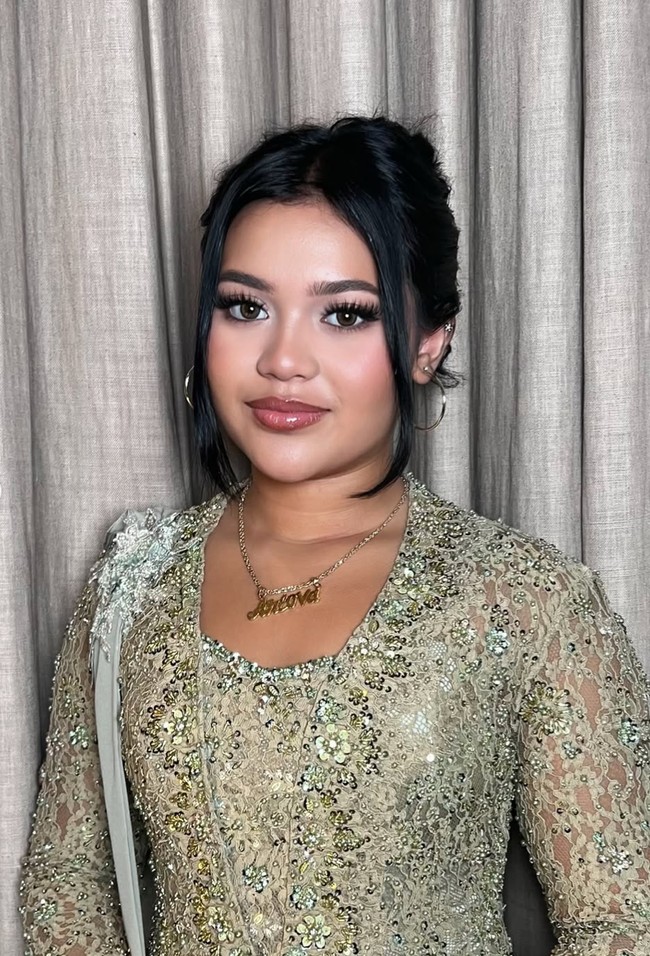 Penampilan Lova makin memukau dengan riasan glam look hasil tangan MUA Dorothea. Bagian matanya tampak tajam dengan bulu mata panjang dan tebal serta riasan smokey eyes. Foto: Instagram/@dorotheasbeaautybar