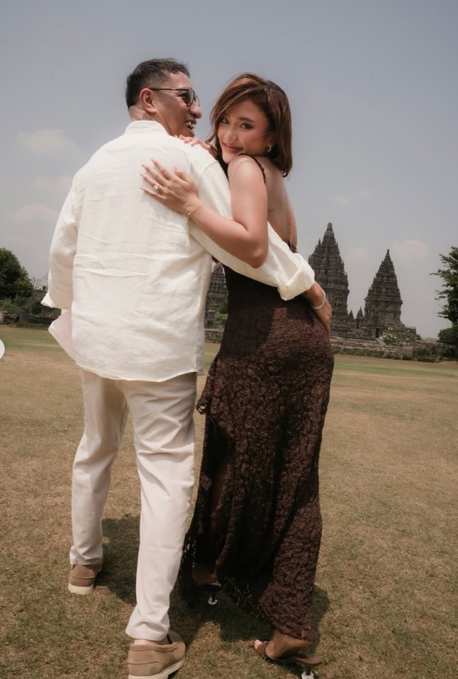 Marion dan Denis tampil kompak dan serasi dalam balutan busana bernuansa coklat. Denis tampil dengan kemeja dan celana linen, sementara Marion mengenakan dress low back tanpa lengan berbahan brukat. Foto: Instagram/@lalamarionmj
