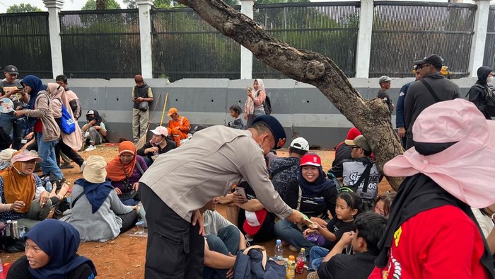 Aksi polisi membagikan roti kepada massa aksi di DPR