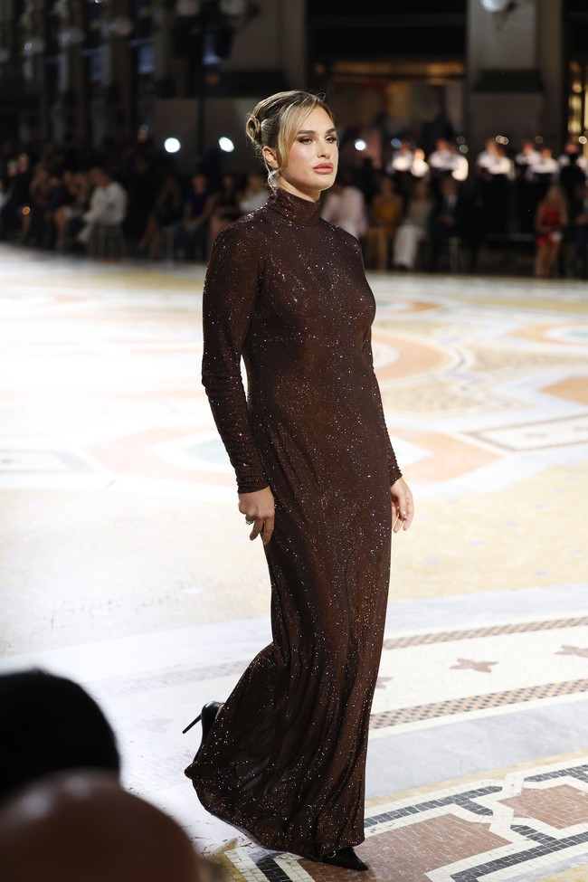 Ia tampak percaya diri saat menelusuri Galleria Vittorio Emanuele II yang tersohor itu. Gaun Gucci yang dikenakannya memiliki siluet pas badan, leher tinggi, serta material berkilauan yang memberikan kesan glamor. (Foto: Arnold Jerocki/Getty Images for Vogue)