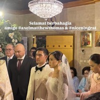 Tampil serasi, Axel dan Cicilia kenakan busana pengantin bernuansa putih. Axel sendiri tampak mengenakan kemeja dan jas putih dipadukan ceelana panjang dan dasi kupu-kupu hitam. Foto: Instagram/@axelmatthewthomas