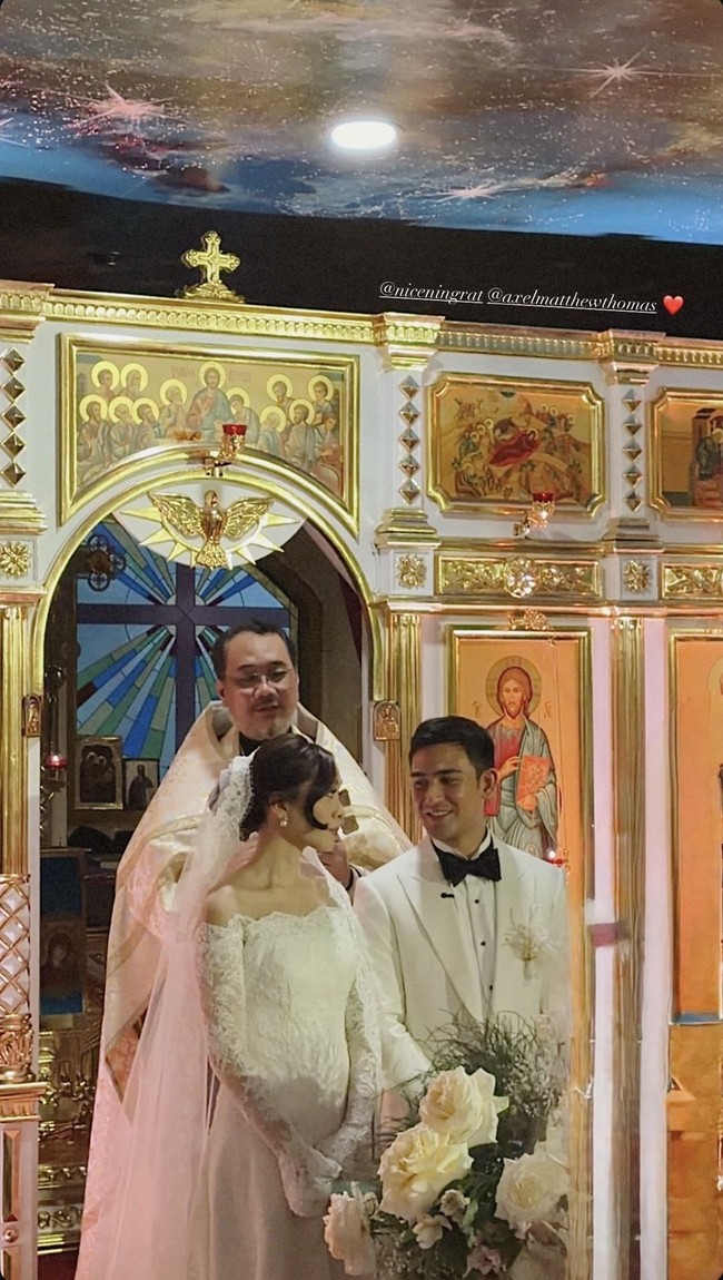 Cicilia tampil cantik dengan rambut yang disanggul rendah. Poni panjang di bagian samping rambut dibiarkan terurai, memberikan efek framing yang lembut pada wajahnya. Foto: Instagram/@axelmatthewthomas
