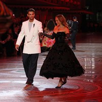 J.Lo berbagi runway dengan Lorenzo Musetti, petenis muda asal Italia yang tampil elegan dalam setelan jas oversized dan celana hitam. Keduanya tampak berdansa dan bergandengan tangan. Foto: Getty Images for Vogue/Stefania M. DAlessandro