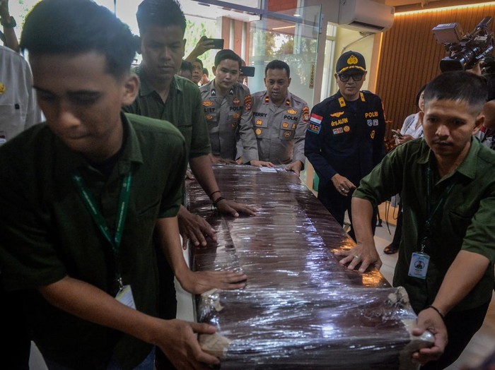 Polisi dan petugas membawa peti jenazah anak buah kapal (ABK) Arupadhatu 1, Surakman di Terminal Kargo Bandara Soekarno-Hatta, Kota Tangerang, Banten, Kamis (24/9/2026). Surakman merupakan salah satu korban hilang kontak rombongan jurnalis saat melakukan peliputan aktivitas Gunung Anak Krakatau tiba di Bandara Soekarno Hatta dan langsung dipulangkan ke kampung halamannya untuk dimakamkan di TPU Ki Demang, Desa Carita, Kabupaten Pandeglang, Banten. ANTARA FOTO/ Putra M. Akbar/wsj.