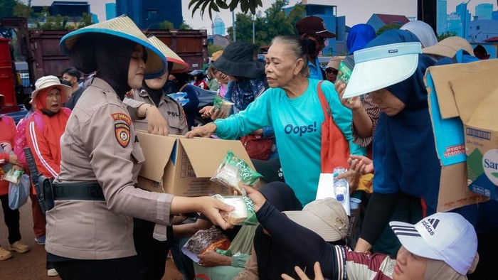 Polisi membagikan makanan dan minuman kepada massa aksi di depan DPR, Jakarta Pusat, Kamis (24/9/2026).