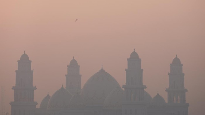 A bird flies over Al Ikhlas Grand Mosque, which is shrouded in haze from wildfires, in Ketapang regency, West Kalimantan province, Indonesia, August 30, 2026. From January to July this year, fires burned around 202,000 hectares (almost 500,000 acres) of land in Indonesia, with West Kalimantan being the worst-hit province, with more than 38,000 hectares burned, government data shows. Firefighting volunteer Elly Marlina, 46, says the fires are worse than normal this year and affecting forests and peatland still struggling to recover from previous seasonal fires, prompting concern about their future. 