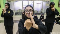 Tiga murid anggota Perguruan Cingkrik Rawa Belong (Percira) memperagakan jurus silat di sela latihan. Malam mulai turun di Rawa Belong, Jakarta Barat. Di Aula Pasar Bunga Rawa Belong, sejumlah pesilat bersiap mengenakan pakaian latihan.