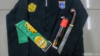 Atribut pencak silat seperti sakral, sabuk (bengkong), dan golok dikenakan pendekar ketika melatih muridnya.
