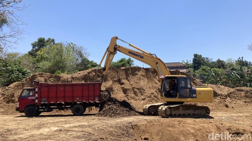 Sebuah ekskavator tengah menurunkan muatan sampah organik yang sudah dicacah di area eks galian C Gunaksa, Kecamatan Dawan, Klungkung, Bali, Sabtu (26/9/2026). (Fatih Kudus Jaelani/detikBali).