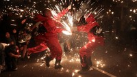 Percikan api yang menyembur dari tongkat para peserta menerangi suasana malam Barcelona. Warga dan wisatawan berkumpul untuk menyaksikan pertunjukan yang menjadi bagian penting dari perayaan La Merce. REUTERS/Nacho Doce